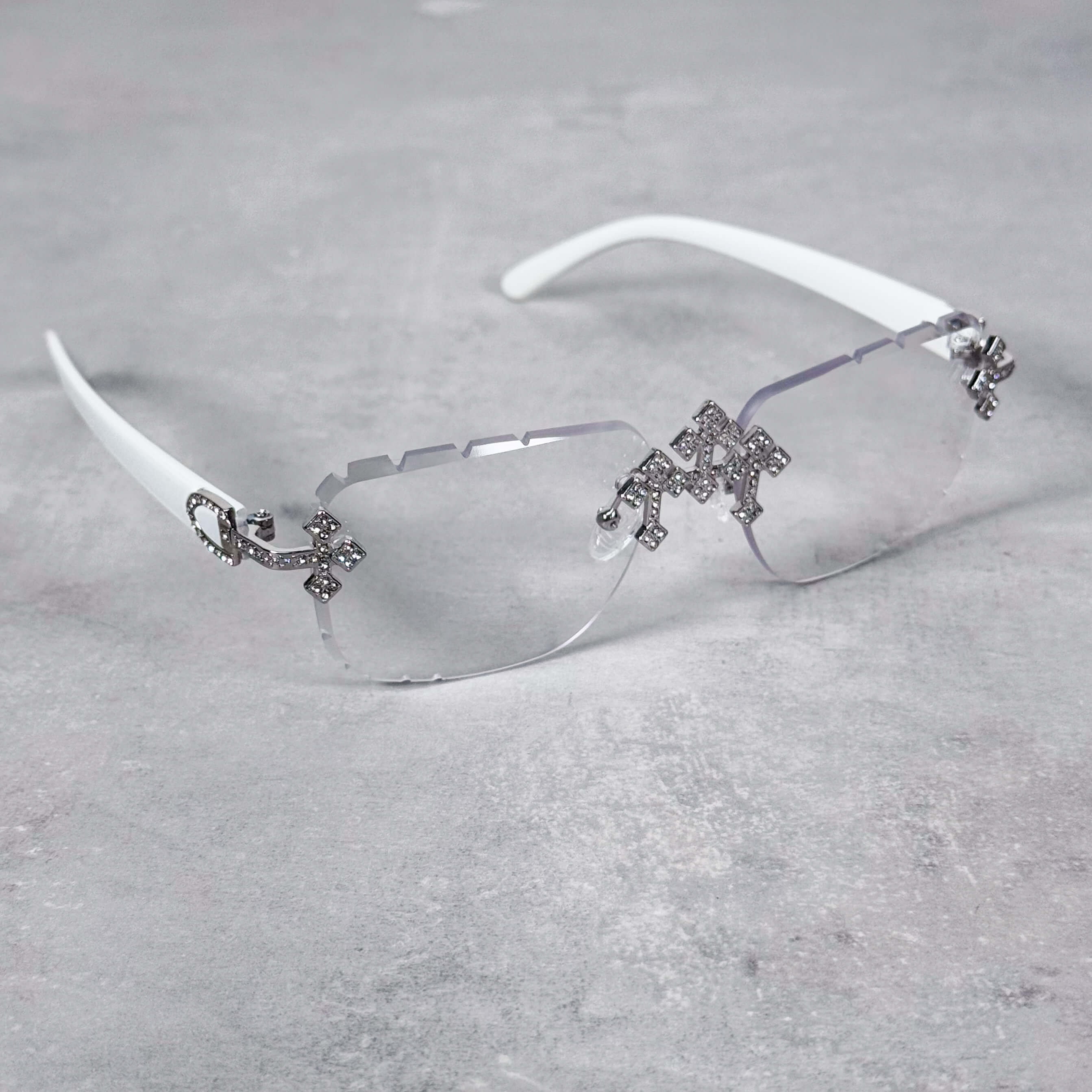 Clear lens white Triple Cross Sunglasses featuring silver iced cross accents and rimless design.