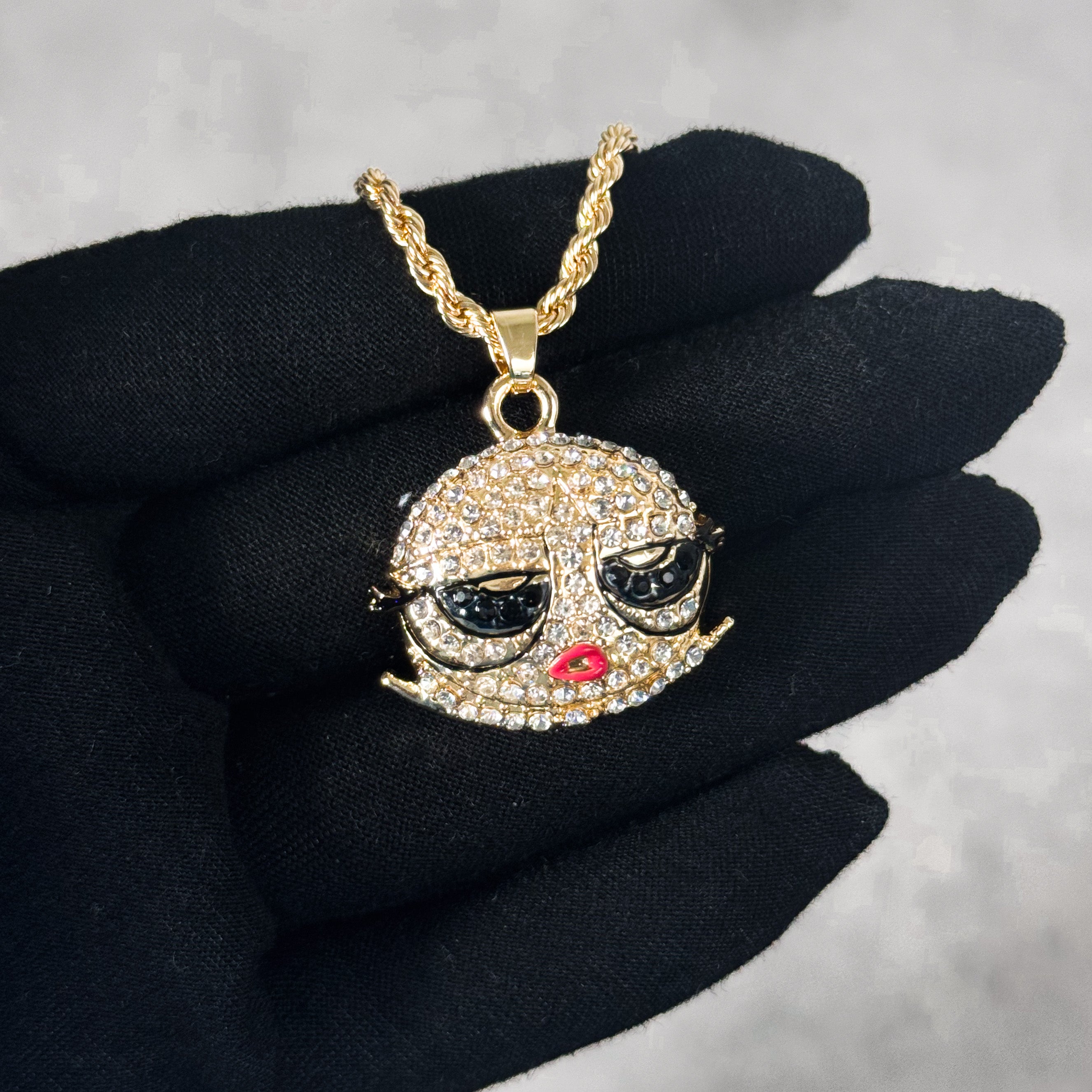 Mini Iced Out Bob Doll Pendant in gold finish with iced details, displayed on hand.