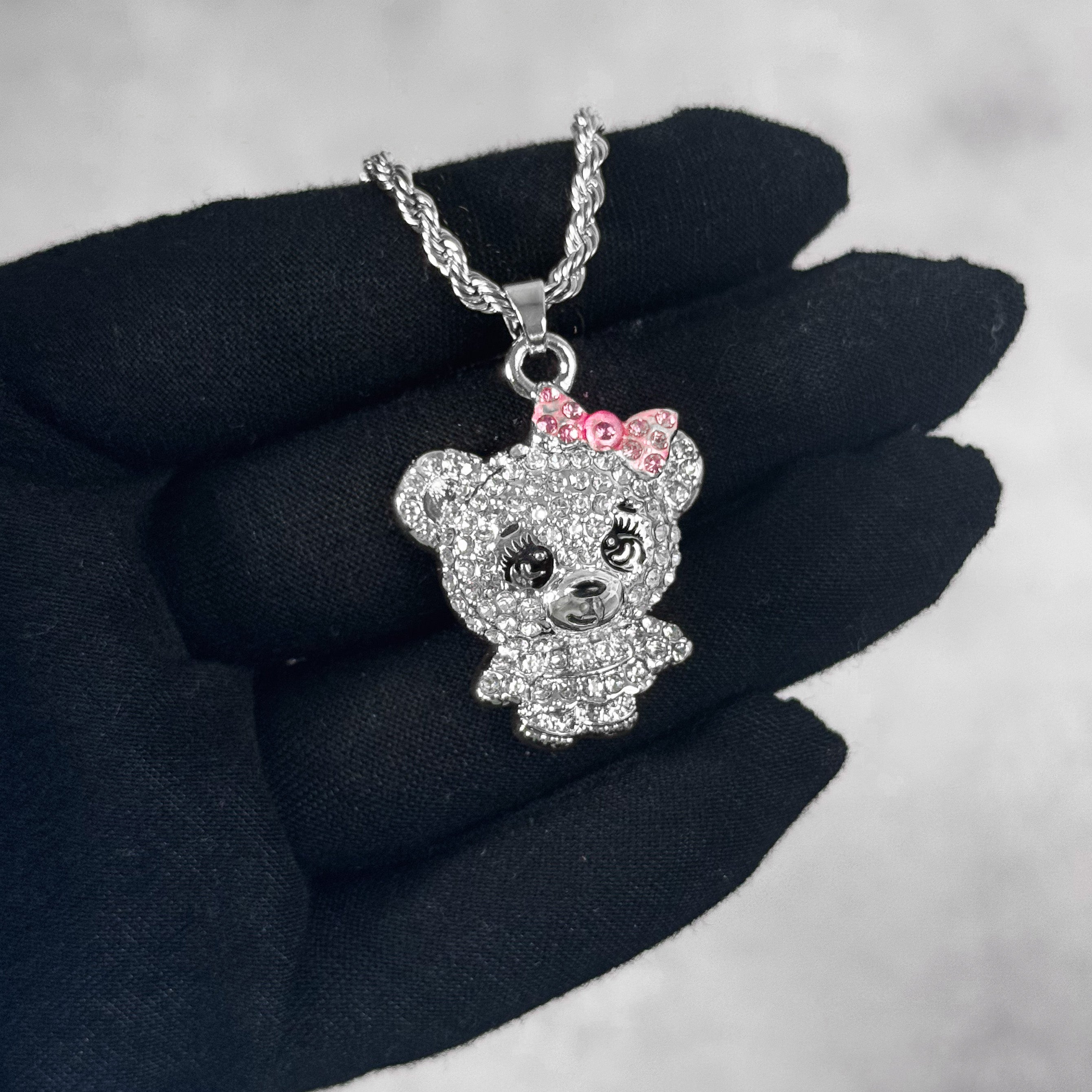 Close-up silver Mini Iced Out Cute Bear Doll Pendant with pink bow and fully iced design.