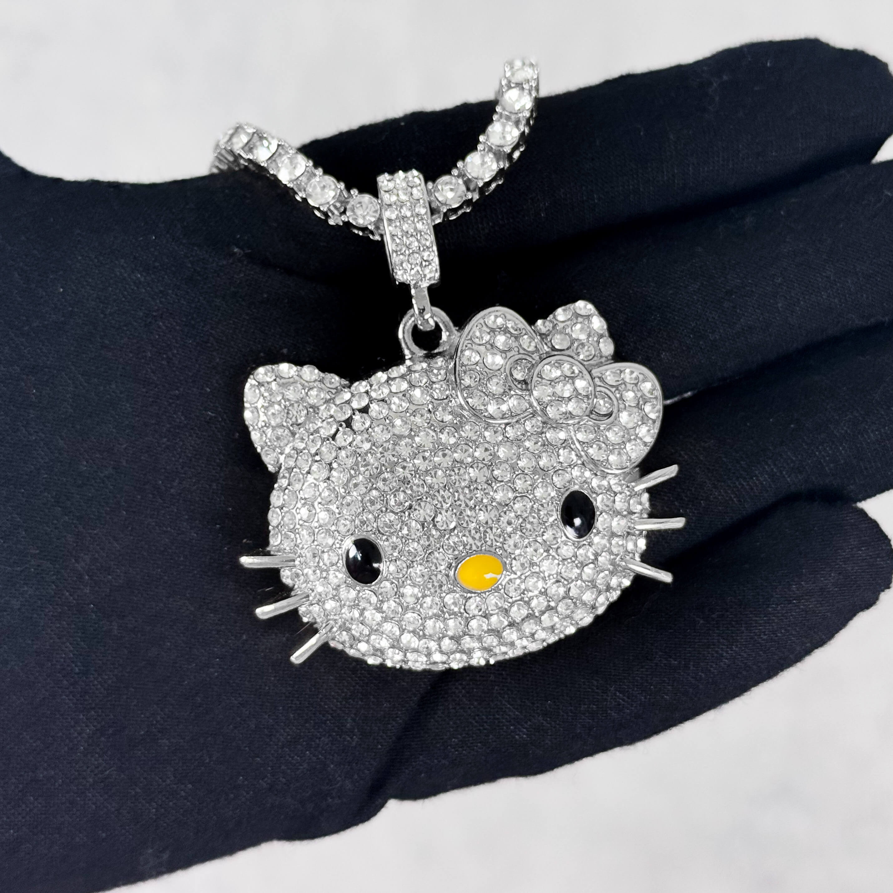 Silver Iced Out Kitty Pendant with Tennis Chain shown in hand, fully iced pavé cat pendant.