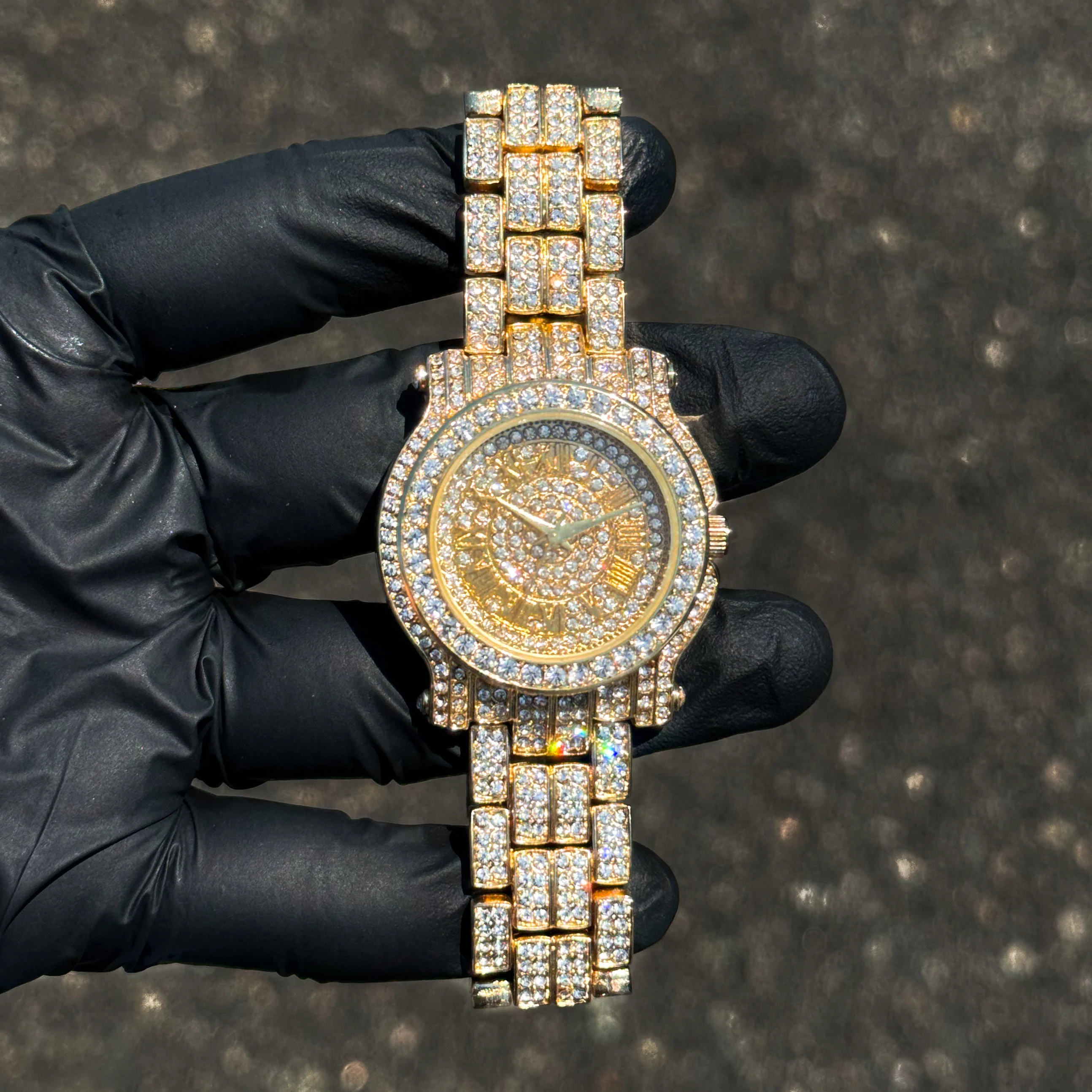 Gold Women’s 35mm diamond watch with iced Roman dial and fully crystal-studded band, quartz.