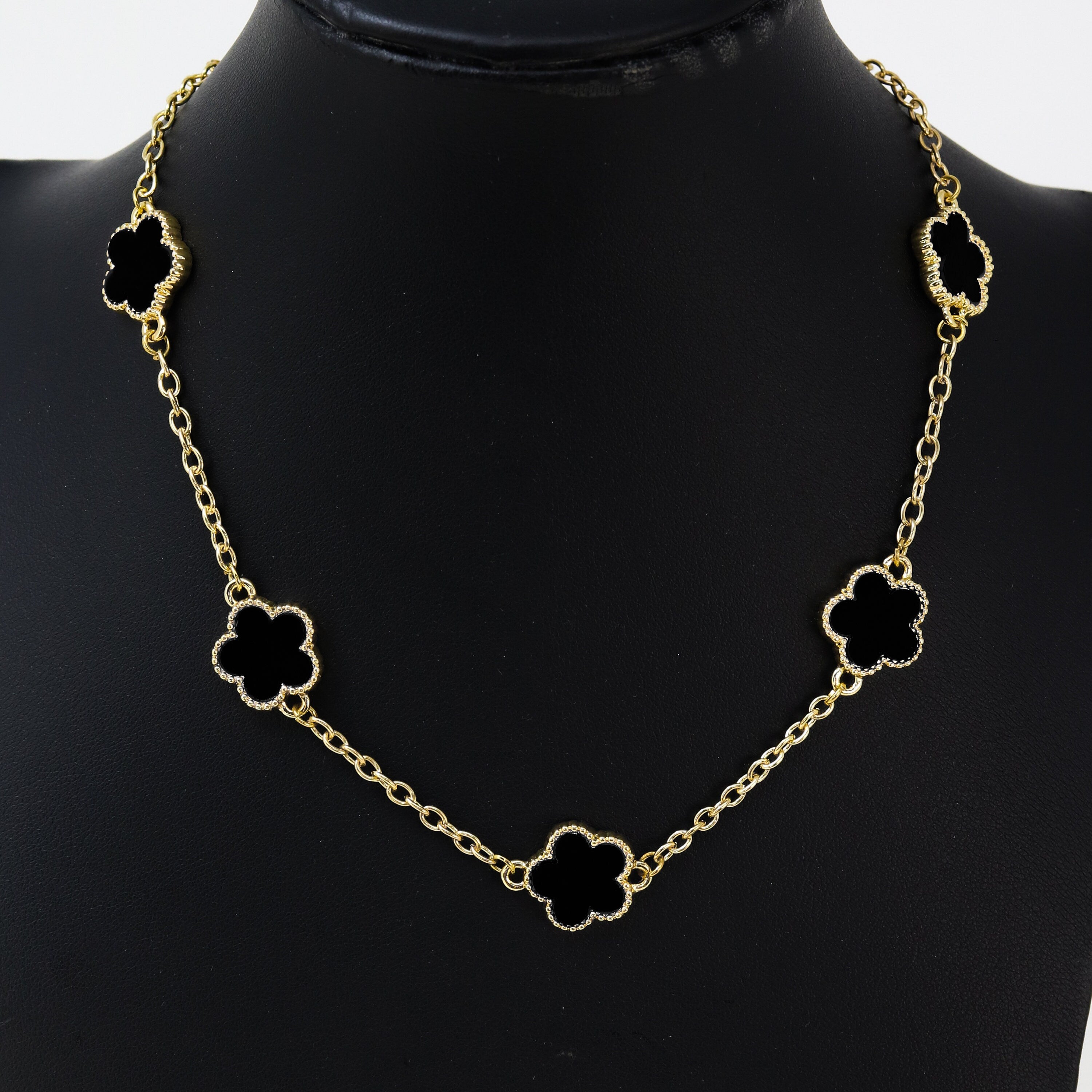 Men's 15mm 5-Leaf Clover Link Chain Necklace in gold finish with black enamel clover charms displayed on stand.