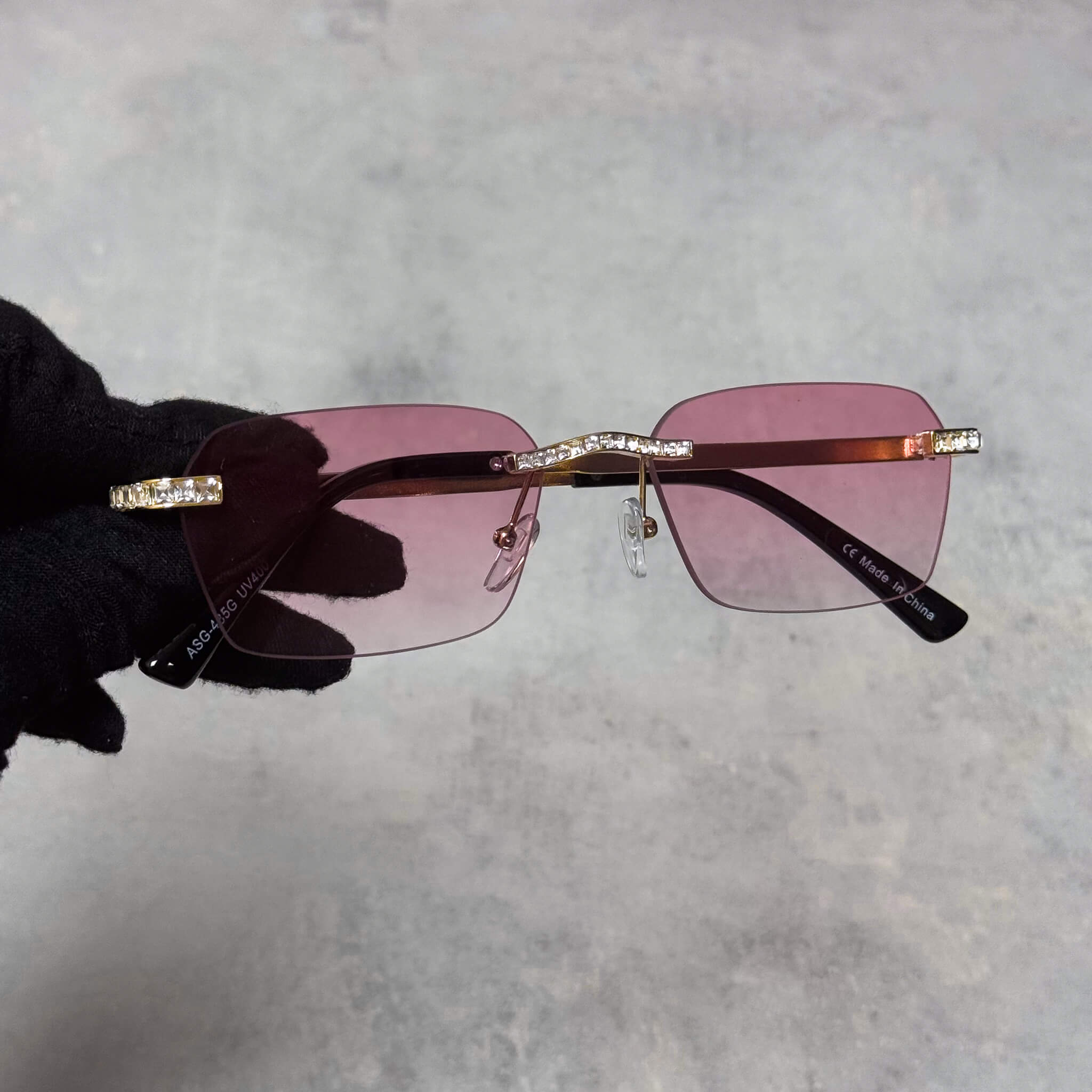 Baguette Stone Sunglasses with pink rectangular lenses and gold crystal-trimmed rimless frame.
