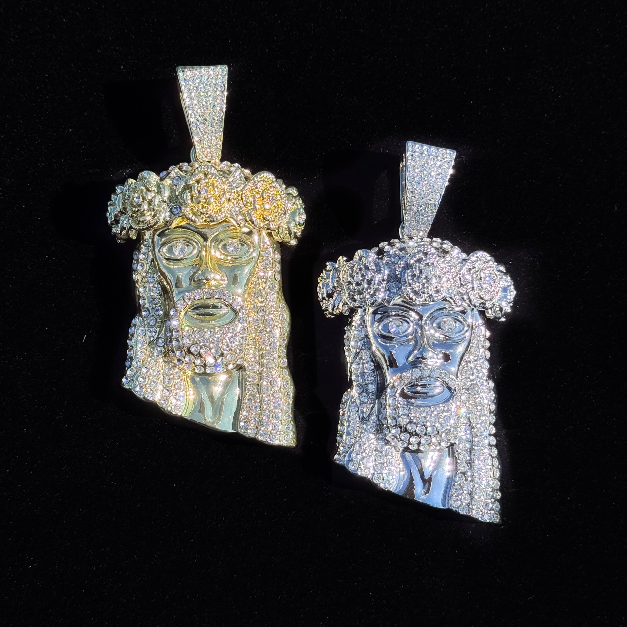 Large gold and silver iced-out Jesus crown pendant with rose detailing shown up close against black.