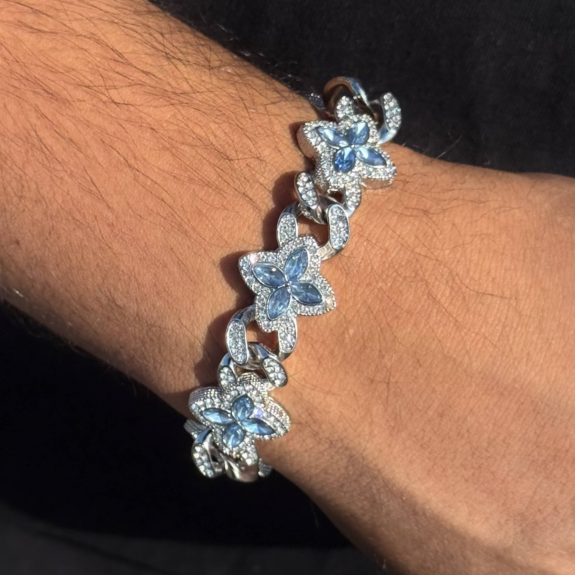 Men’s 20mm Iced Out Clover Link Bracelet in silver displayed on wrist with pavé details.