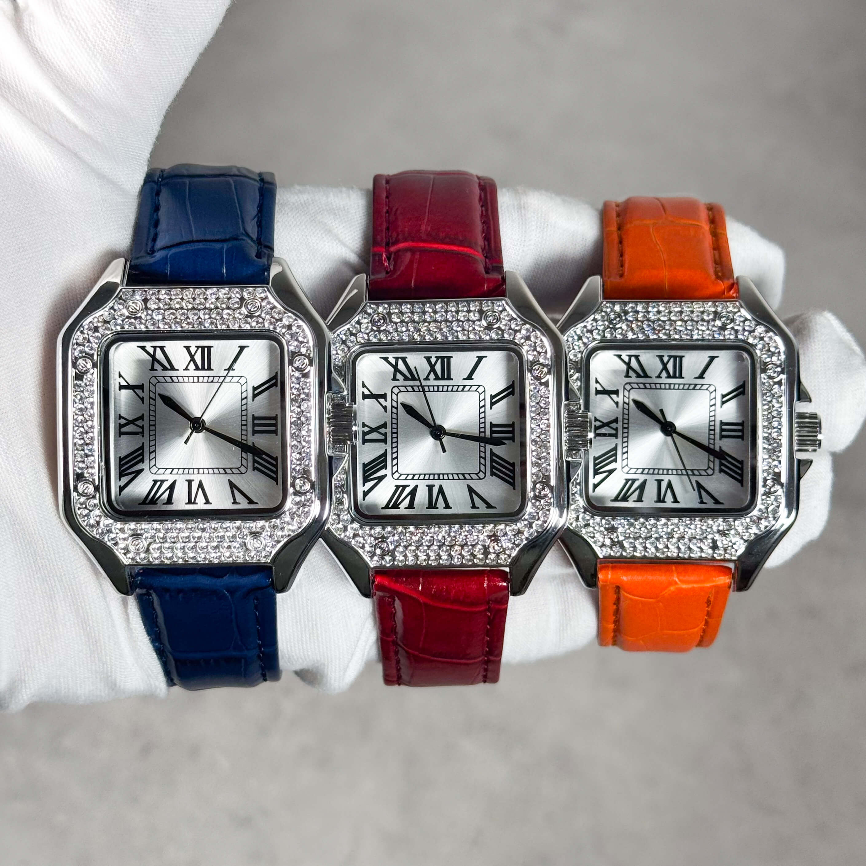 Men's 32mm square dial watch with silver face, crystal bezel and blue leather band in a stylish display.