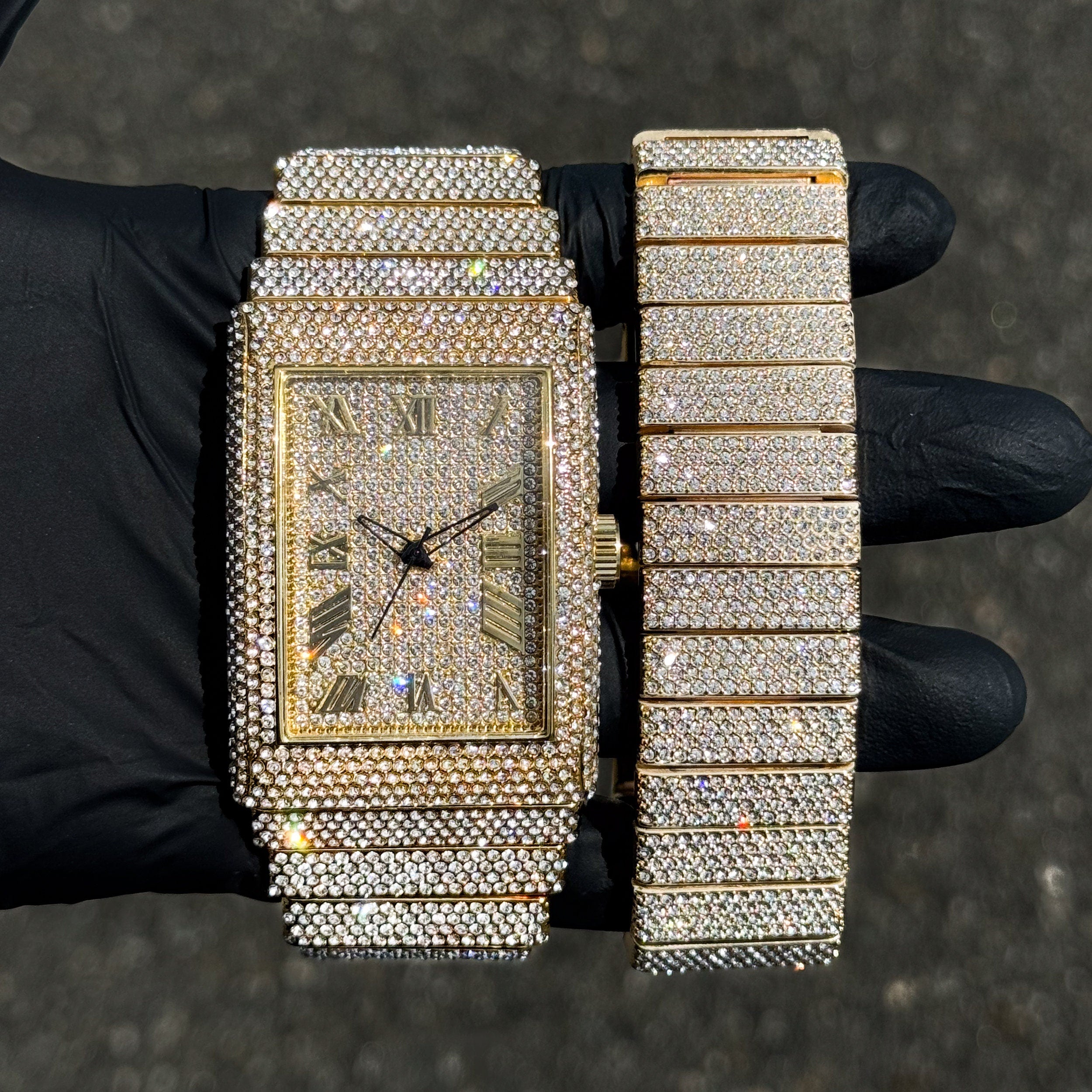 Men's 40mm gold fully iced out watch with matching diamond bracelet set shown in hand.