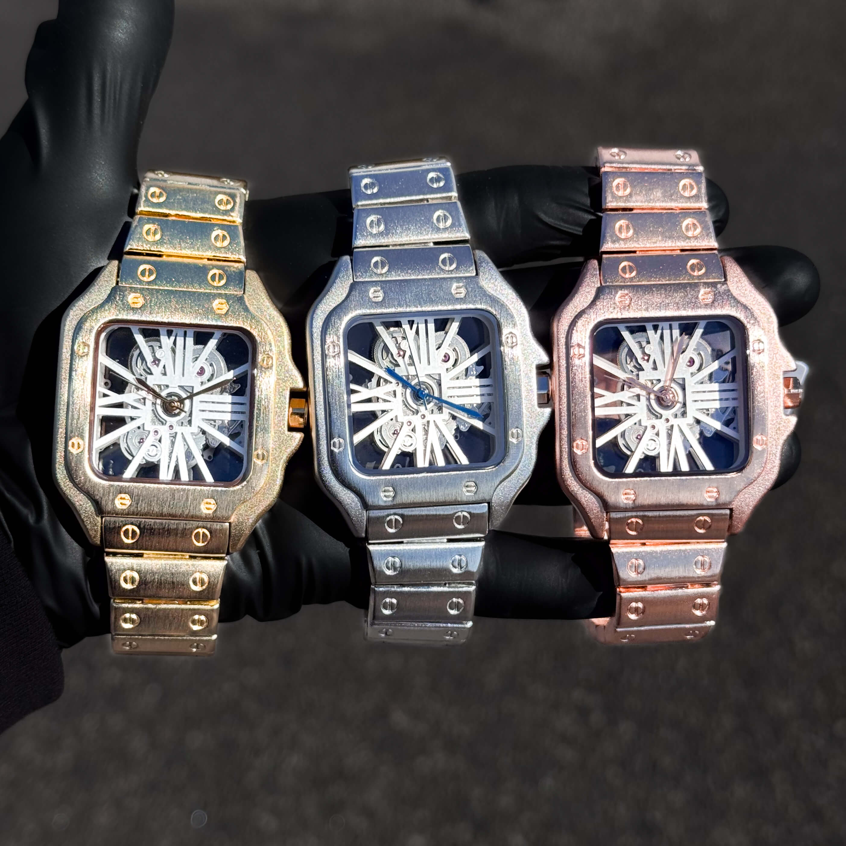 Men's 40mm square skeleton watches in gold, silver, and rose gold with brushed metal bands.