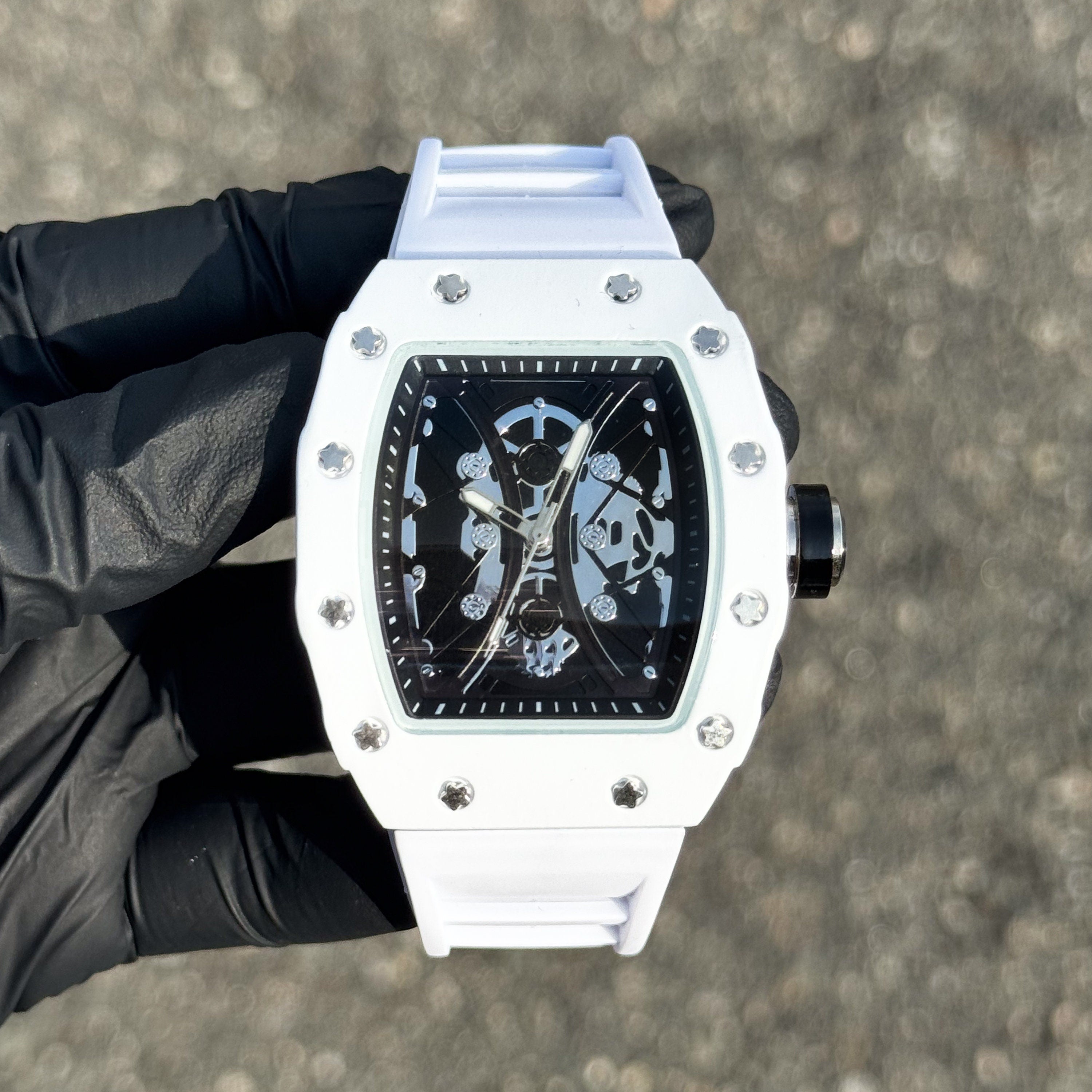 Men's 42mm white tonneau watch with skeleton dial, matte case and adjustable silicone band.