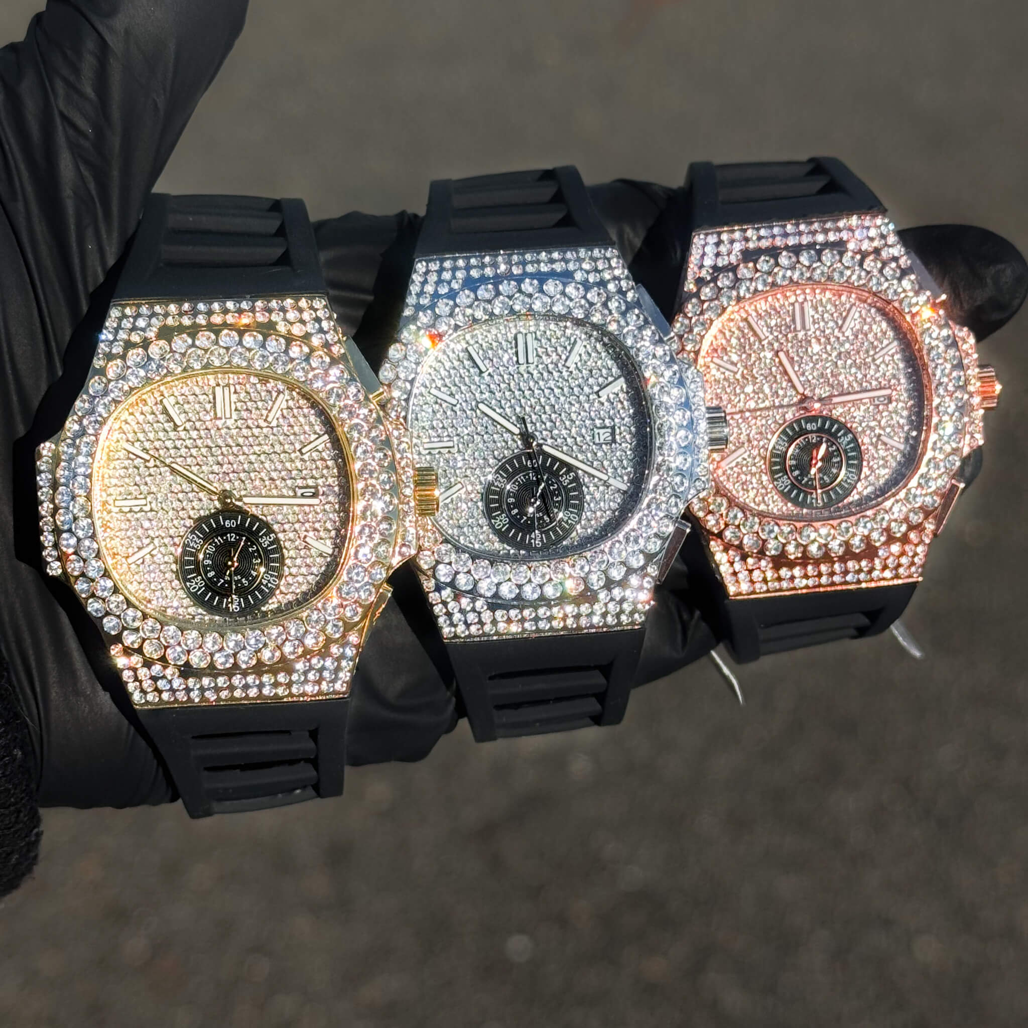 Men's 43mm iced out silicone band watches with oblong diamond bezels in gold, silver, and rose gold.