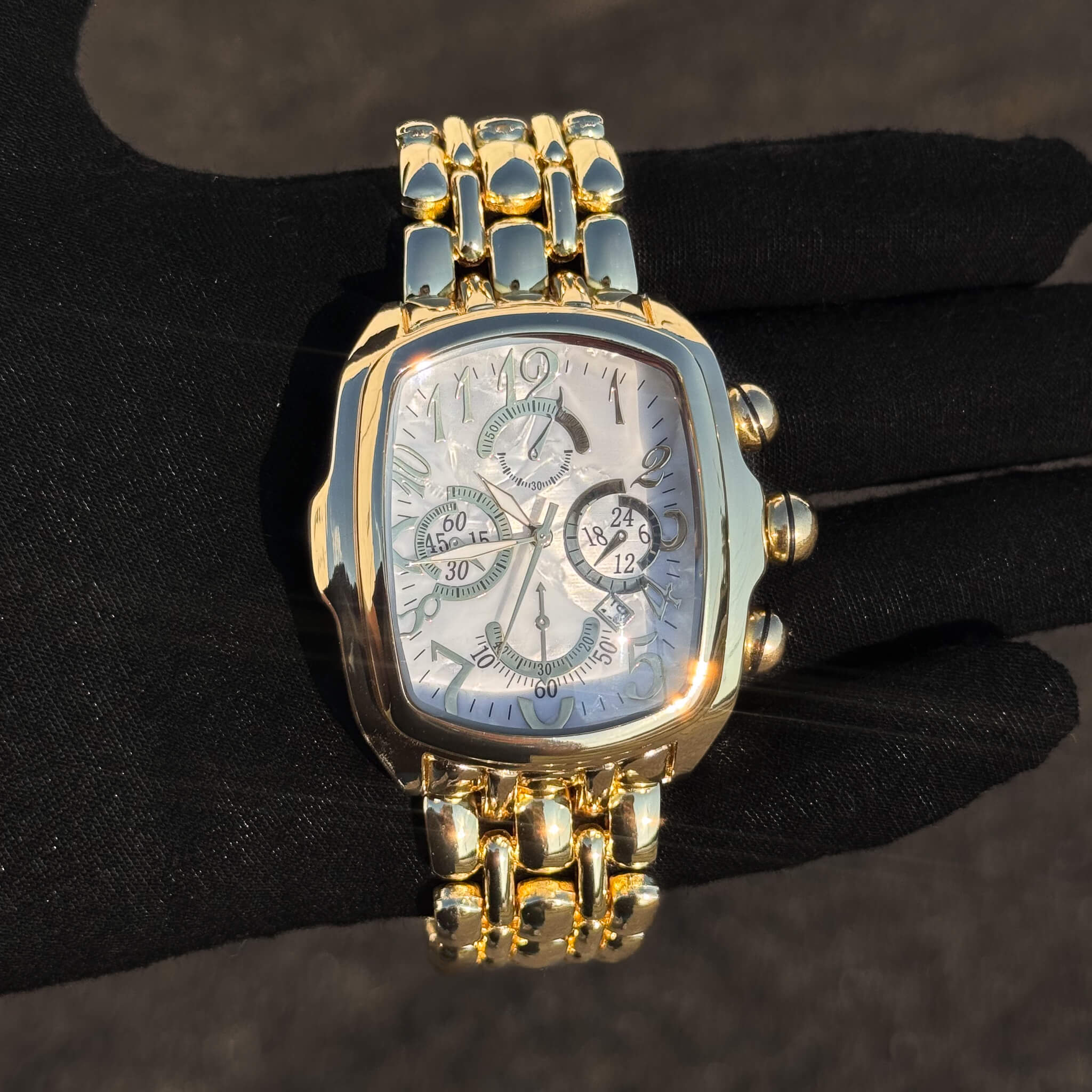 Men’s 43mm tonneau watch with gold metal band, white multi-dial face, and quartz movement.