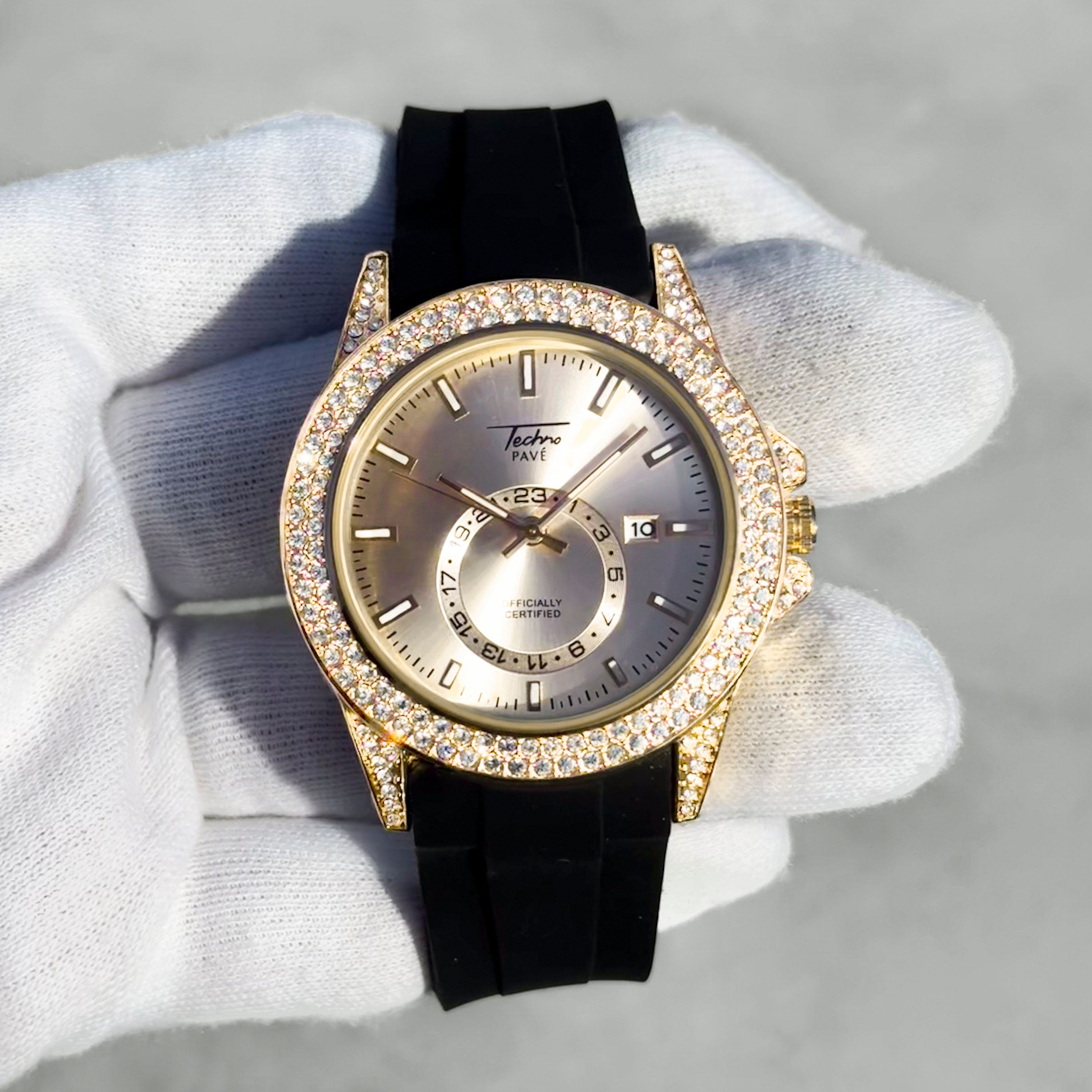 Men’s 42mm gold diamond watch with iced-out bezel, silver dial, and black silicone band.