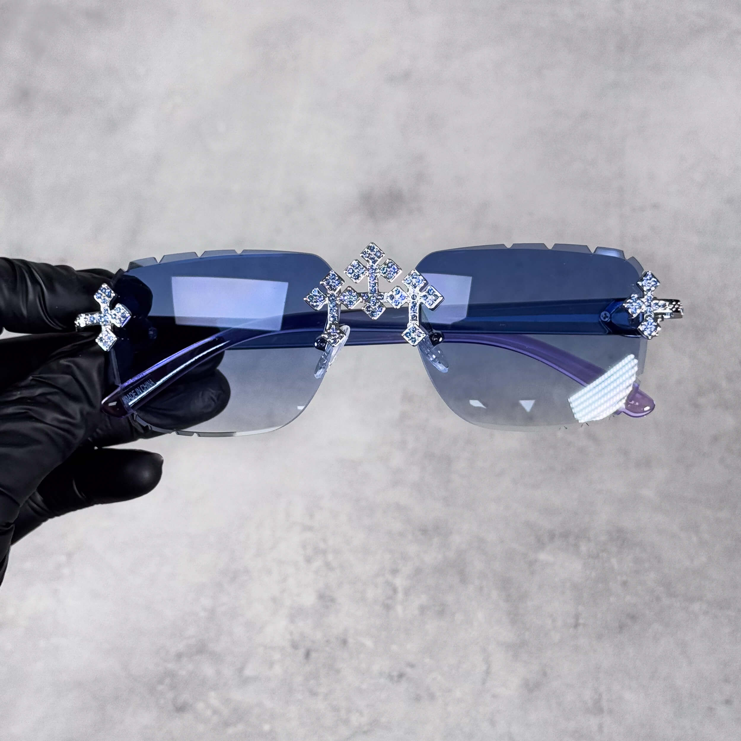 Iced Triple Cross Sunglasses with blue gradient lenses and crystal cross accents on rimless frame.