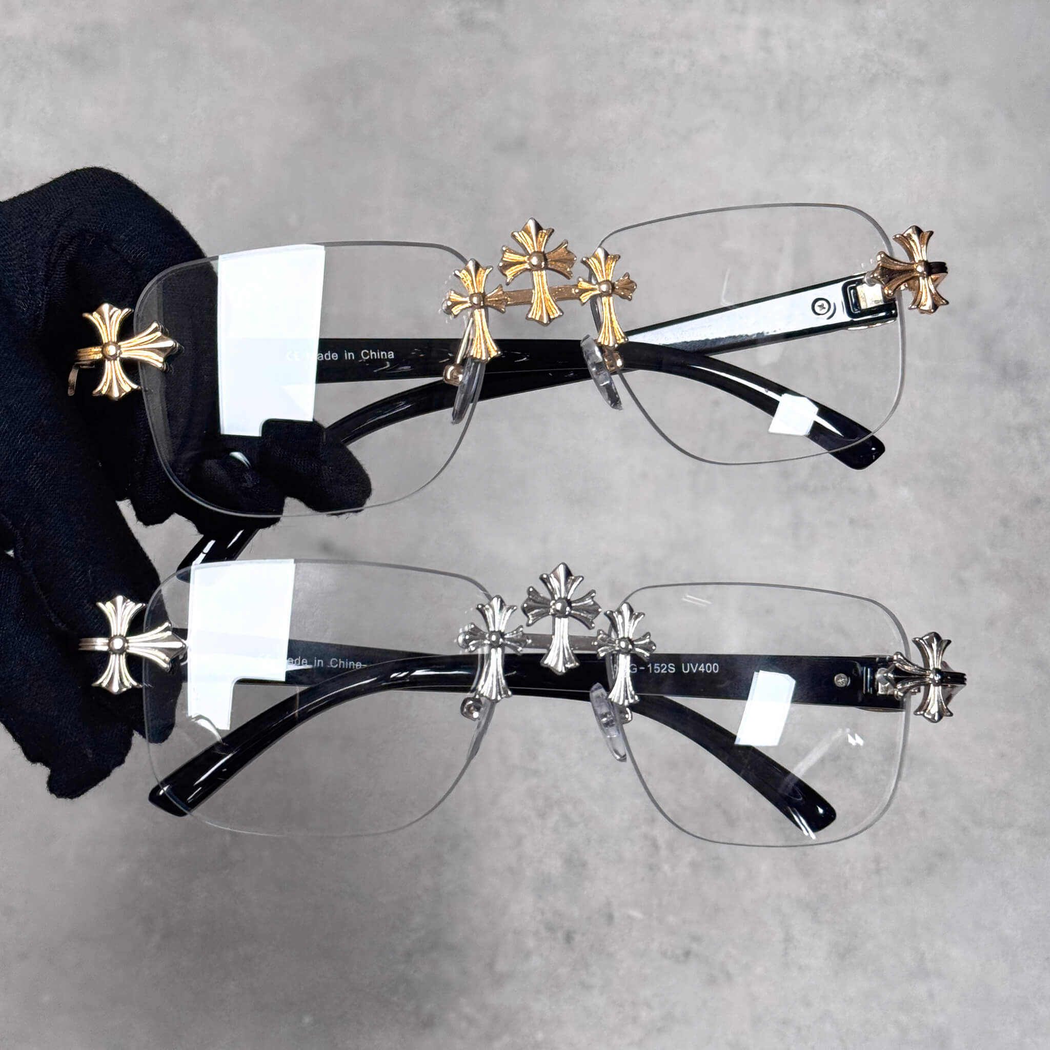 Solid Triple Cross Sunglasses with clear lenses and gold and silvr cross accents on black temples.